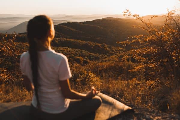 Mujer embarazada haciendo yoga en la naturaleza