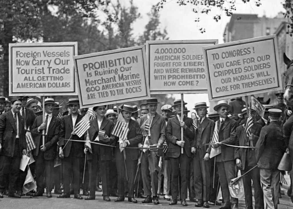 Protesta en cotra de la Prohibición, en Nueva York. En las pancartas se puede leer: "4,000,000 soldados americanos lucharon por la libertad y fueron recompensados con la Prohibición. ¿Cómo es eso?", "La Prohibición está arruinando nuestra marina mercante. 600 buques americanos están atados a los muelles."