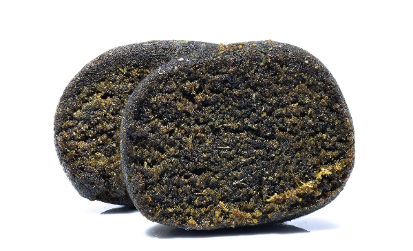 Charas: two pieces of dark hand-rubbed resin hash, with greenish tones