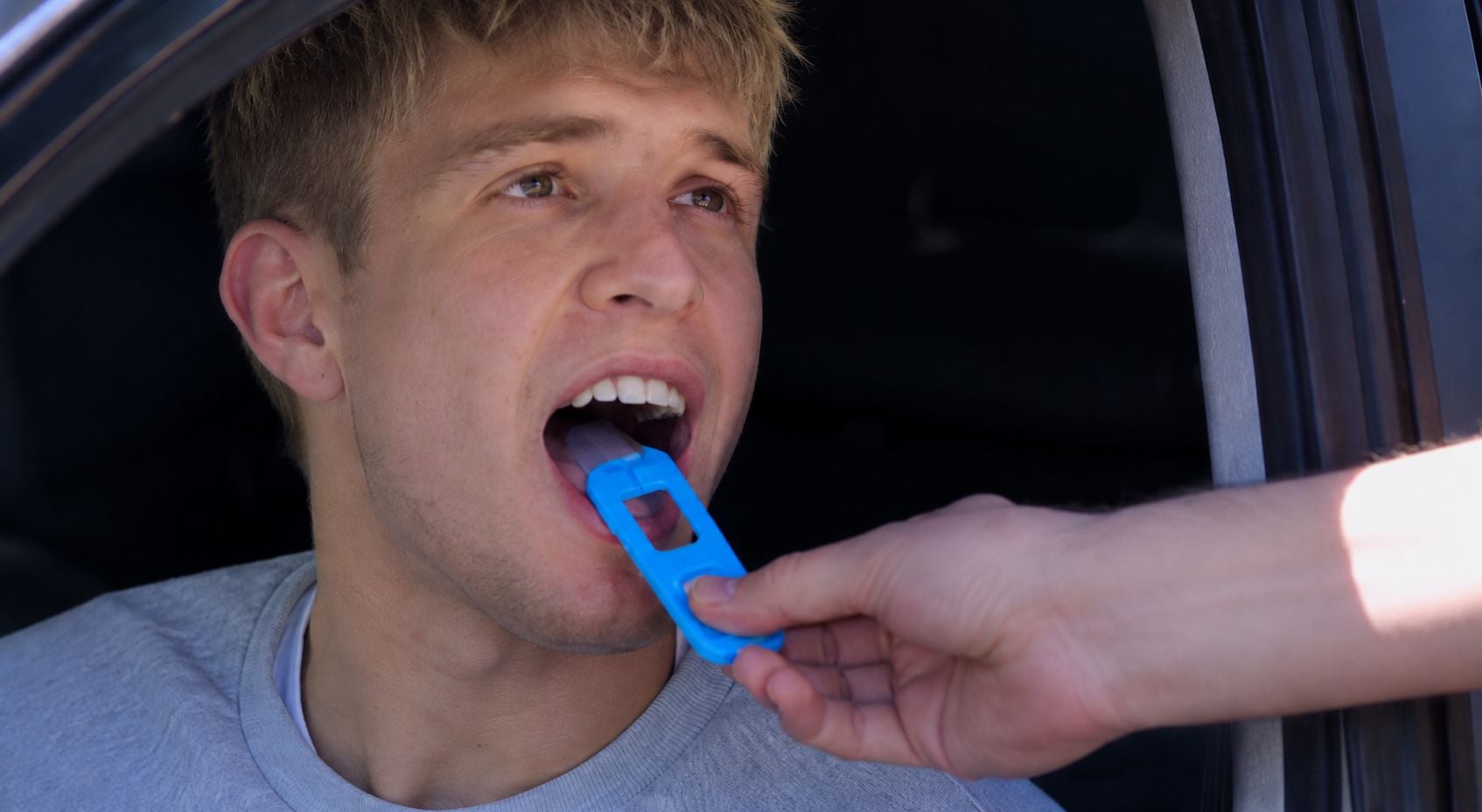 How the DGT saliva test works: an officer collects the sample with the strip ("the lollipop") that the driver rubs on their tongue